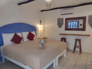 ein Schlafzimmer mit einem Bett mit einem Teddybär drauf in der Unterkunft MIO Tulum Hotel Boutique in Tulum