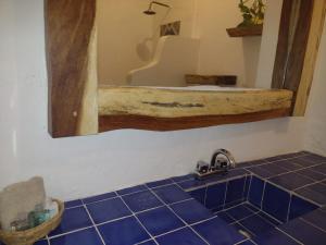 La salle de bains est pourvue d'un lavabo, d'un miroir et de carrelage bleu. dans l'établissement MIO Tulum Hotel Boutique, à Tulum