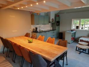 eine Küche und ein Esszimmer mit einem Holztisch und Stühlen in der Unterkunft B&B De Oase in Bergambacht