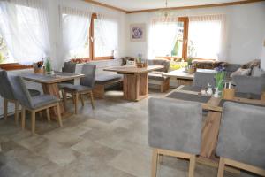 ein Wohnzimmer mit Tischen, Stühlen und einem Sofa in der Unterkunft Pension Eule in Sankt Kanzian am Klopeiner See