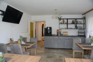 ein Restaurant mit Tischen und Stühlen und einem TV an der Wand in der Unterkunft Pension Eule in Sankt Kanzian am Klopeiner See