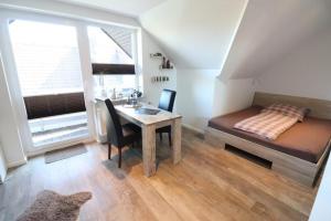 una camera da letto con scrivania, letto e tavolo di Appartementhaus-Kogge-Wohnung-8 a Cuxhaven