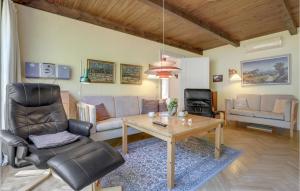 a living room with a couch and a table and chairs at Nice Home In Nexø With Wifi in Neksø
