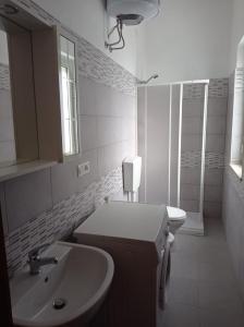 ein weißes Badezimmer mit einem Waschbecken und einem Spiegel in der Unterkunft Casa Belvedere in Belvedere Marittimo