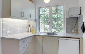 a kitchen with white cabinets and a sink at Nice Home In Nexø With Wifi in Neksø