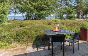 a black table with chairs and a table with a view of the ocean at Nice Home In Nexø With Wifi in Neksø +21 photos