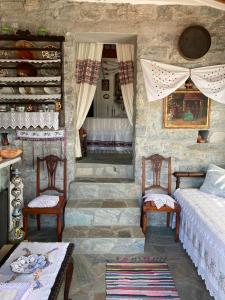 a room with two chairs and a bed and a staircase at Melissa Apartments in Anogia