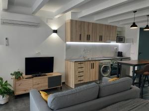 a living room with a couch and a tv and a kitchen at Loft 4 MORELLA in Morella