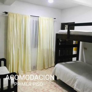 1 dormitorio con 2 literas y ventana en Hostal Diana, en San Agustín
