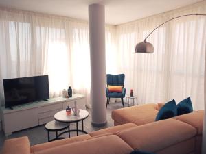 sala de estar con sofá y TV en Skyline Suites Costa del Sol, en Torremolinos