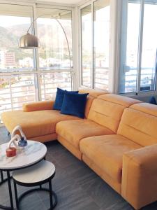 sala de estar con sofá naranja y mesa en Skyline Suites Costa del Sol, en Torremolinos