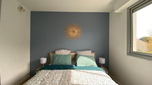 um quarto com uma cama com paredes azuis e uma janela em LE CYLIA em Mérignac