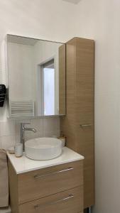 uma casa de banho com um lavatório e um espelho em LE CYLIA em Mérignac