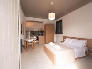 a bedroom with a bed and a table and a kitchen at STARI in Kattavía