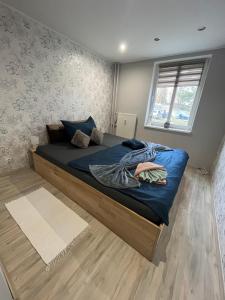 Schlafzimmer mit einem Bett mit blauer Bettwäsche und einem Fenster in der Unterkunft Ubytovanie pod štítmi Vysokých Tatier in Tatranska Strba