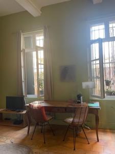 Cette chambre comprend un bureau avec des chaises et des fenêtres. dans l'établissement Peyrou, studio la merci, 3 étoiles, à Montpellier