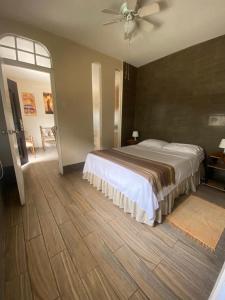 1 dormitorio con 1 cama y ventilador de techo en El Patio Suites, en Guayaquil