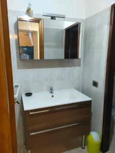uma casa de banho com um lavatório e um espelho em La casa di Zahra em Riccò del Golfo di Spezia
