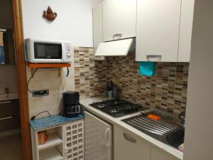 uma pequena cozinha com fogão e micro-ondas em La casa di Zahra em Riccò del Golfo di Spezia