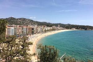 a view of a beach with buildings and the ocean at Central Beach Modernist Apartment in Lloret de Mar