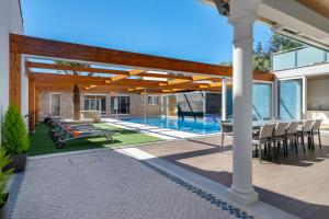 een patio met een tafel en stoelen en een zwembad bij WHome Hideaway Luxury Family Villa w/ S-Pool & AC in Ourém