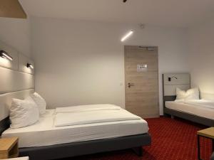 1 Schlafzimmer mit 2 Betten und einer Tür zu einem Zimmer in der Unterkunft Hotel Continental in Nürnberg