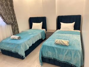 two beds sitting next to each other in a room at Pyramids View Apartment in Giza