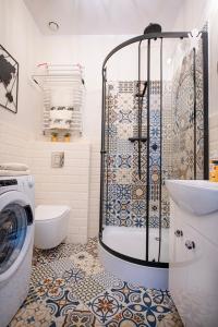 a bathroom with a shower and a washing machine at Apartament u Olechny 3 in Bydgoszcz