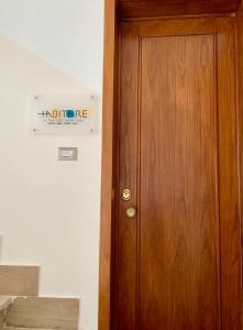 Una puerta de madera en una habitación con un cartel. en HABITARE Lecce & Salento, en Lecce