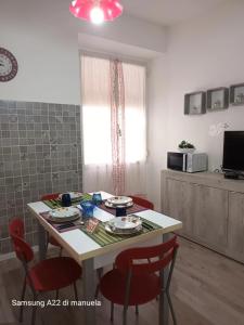 a kitchen with a table with red chairs and a tableablish at GAIA Accommodation in Alghero