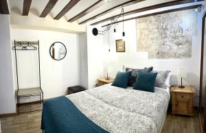 um quarto com uma cama grande e almofadas azuis em Apart. Entrepatios em Toledo