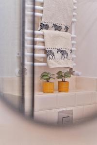 a towel rack with towels and potted plants on it at Apartament u Olechny 3 in Bydgoszcz