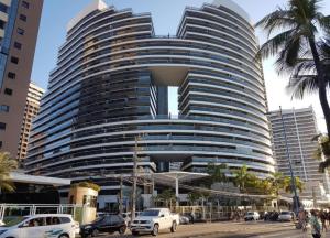 a large building with cars parked in front of it at Beira Mar Fortaleza Landscape in Fortaleza