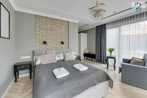 a bedroom with a large bed and a living room at MS Apartments Rest 5.0 in Sopot