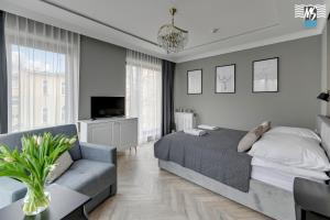 a bedroom with a bed and a couch and a tv at MS Apartments Rest 5.0 in Sopot