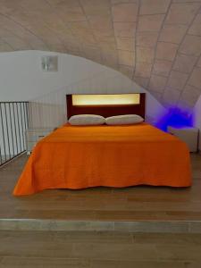 um quarto com uma cama laranja e 2 almofadas em Casa Vacanza , Marianna em Nápoles