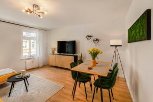 salon ze stołem, krzesłami i telewizorem w obiekcie Levax Living - Cozy - Clarapark - citynah w Lipsku