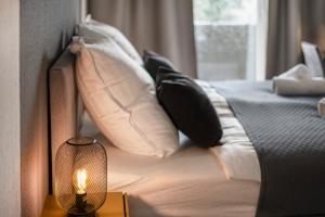ein Bett mit Kissen und einer Lampe auf einem Tisch in der Unterkunft Levax Living - Cozy - Clarapark - citynah in Leipzig