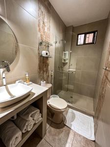 uma casa de banho com um lavatório, um WC e um chuveiro em El Patio Suites em Guayaquil