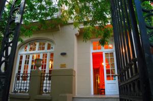 a house with a red door and a gate at Hotel De La Rue in Buenos Aires
