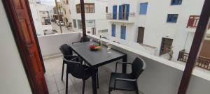 una mesa negra y sillas en el balcón en Kapetanos Rooms en Naxos