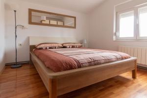 1 dormitorio con 1 cama grande y suelo de madera en Modern Apartment Sara-near the beach, en Privlaka