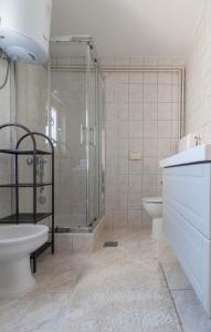 y baño con ducha, aseo y lavamanos. en Modern Apartment Sara-near the beach, en Privlaka