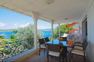 eine Veranda mit einem Tisch und Stühlen auf dem Balkon in der Unterkunft Bodrum’da Özel İskeleli 4+1 Yalı Dairesi in Bodrum City