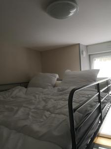 a large bed in a bedroom with a light at Appartement idéalement situé in Le Mont-Dore