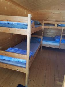 a room with three bunk beds in a cabin at Schöne Stuga unmittelbar am Ammerån gelegen in Hammarstrand