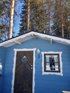 a blue house with a window and a door at Schöne Stuga unmittelbar am Ammerån gelegen in Hammarstrand