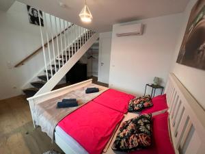 ウィーンにあるTina´s Apartmentのベッドルーム1室(赤いシーツと階段付)