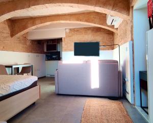 una camera da letto con un letto e una TV in una stanza di Tide 21 Savynomad Harbour Residences Valletta a La Valletta