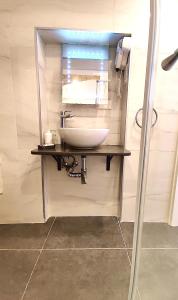 un bagno con lavandino e specchio di Tide 21 Savynomad Harbour Residences Valletta a La Valletta Altre 21 foto